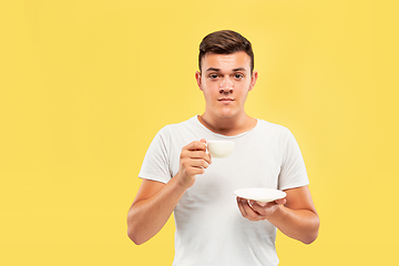 Image showing Caucasian young man\'s half-length portrait on yellow background