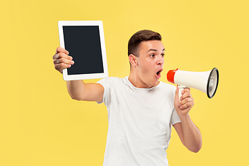 Image showing Caucasian young man\'s half-length portrait on yellow background