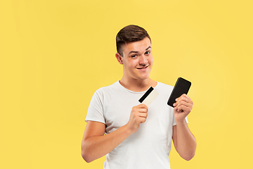 Image showing Caucasian young man\'s half-length portrait on yellow background