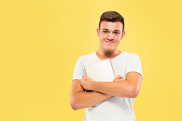 Image showing Caucasian young man\'s half-length portrait on yellow background