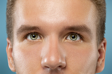 Image showing Caucasian young man\'s close up portrait on blue background