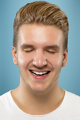 Image showing Caucasian young man\'s close up portrait on blue background