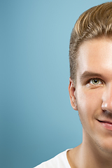 Image showing Caucasian young man\'s close up portrait on blue background