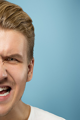 Image showing Caucasian young man\'s close up portrait on blue background