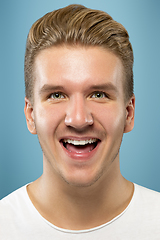 Image showing Caucasian young man\'s close up portrait on blue background