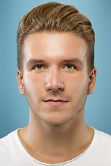 Image showing Caucasian young man\'s close up portrait on blue background