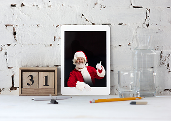 Image showing Happy Christmas Santa Claus shows thumb up in tablet