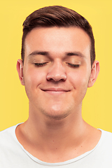 Image showing Caucasian young man\'s close up portrait on yellow background
