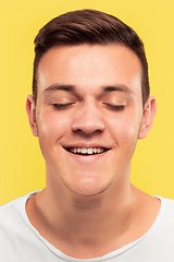 Image showing Caucasian young man\'s close up portrait on yellow background