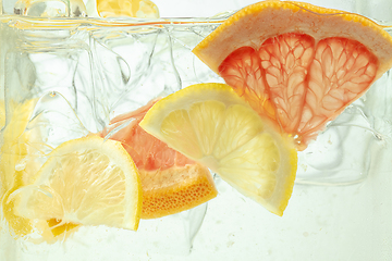 Image showing Close up view of the lemon and grapefruit slices in lemonade on background