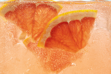 Image showing Close up view of the lemon and grapefruit slices in lemonade on background