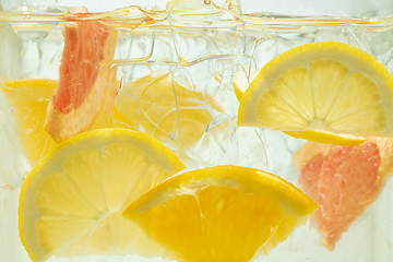 Image showing Close up view of the lemon and grapefruit slices in lemonade on background