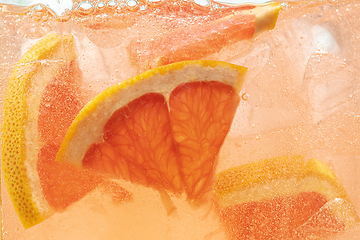 Image showing Close up view of the lemon and grapefruit slices in lemonade on background