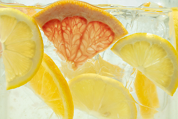Image showing Close up view of the lemon and grapefruit slices in lemonade on background