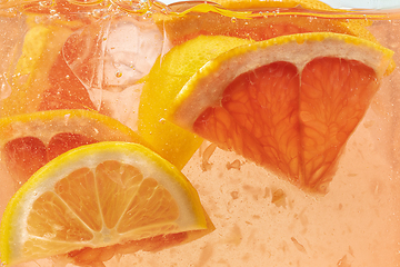 Image showing Close up view of the lemon and grapefruit slices in lemonade on background