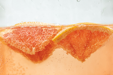 Image showing Close up view of the lemon and grapefruit slices in lemonade on background