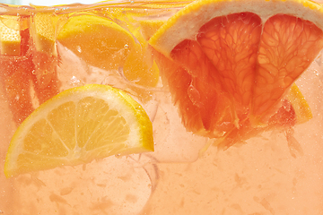 Image showing Close up view of the lemon and grapefruit slices in lemonade on background