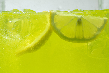 Image showing Close up view of the lemon slices in lemonade on background