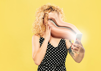 Image showing Young woman engaged by gadget and social media isolated on yellow background