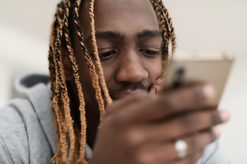 Image showing afro guy uses a cell phone and browses social media during a pandemic