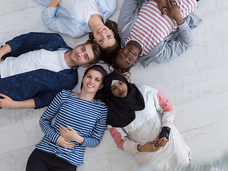 Image showing top view of a diverse group of people lying on the floor and symbolizing togetherness