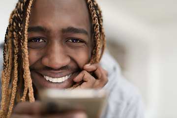 Image showing afro guy uses a cell phone and browses social media during a pandemic