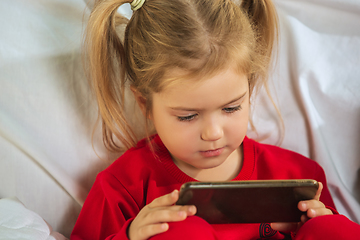 Image showing Little girl in soft warm pajama playing at home