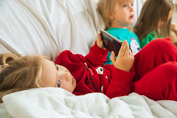 Image showing Little girls in soft warm pajamas playing at home