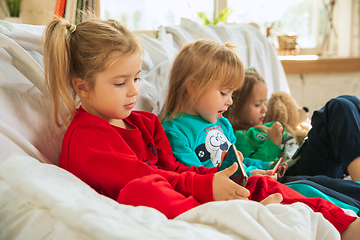 Image showing Little girls in soft warm pajamas playing at home