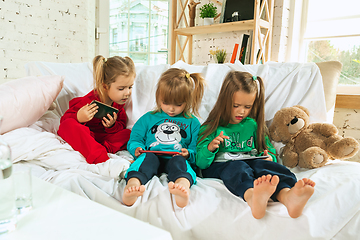 Image showing Little girls in soft warm pajamas playing at home