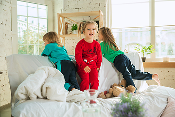 Image showing Little girls in soft warm pajamas playing at home