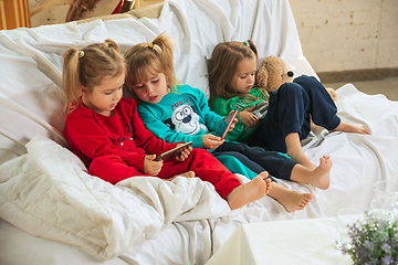 Image showing Little girls in soft warm pajamas playing at home