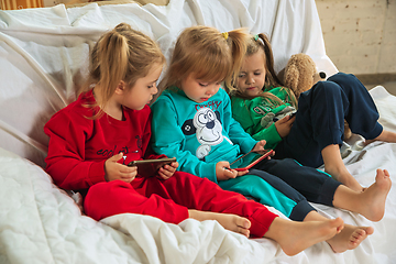 Image showing Little girls in soft warm pajamas playing at home