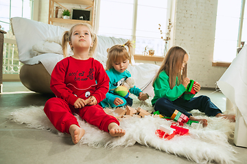 Image showing Little girls in soft warm pajamas playing at home