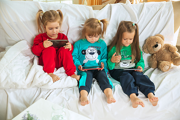 Image showing Little girls in soft warm pajamas playing at home