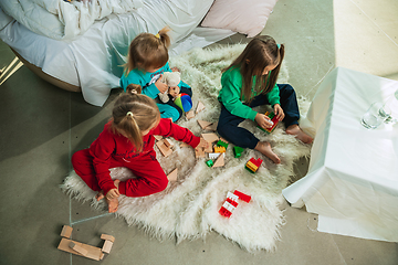 Image showing Little girls in soft warm pajamas playing at home