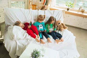 Image showing Little girls in soft warm pajamas playing at home