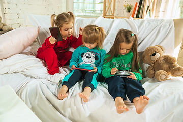 Image showing Little girls in soft warm pajamas playing at home