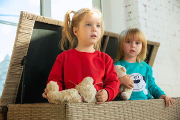 Image showing Little girls in soft warm pajamas playing at home