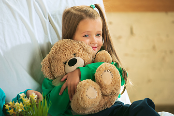 Image showing Little girl in soft warm pajama playing at home