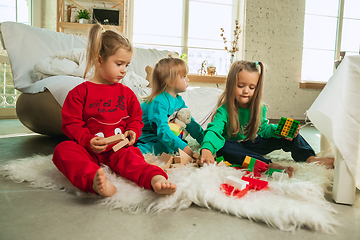 Image showing Little girls in soft warm pajamas playing at home