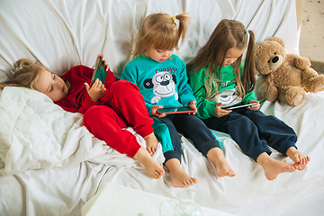 Image showing Little girls in soft warm pajamas playing at home