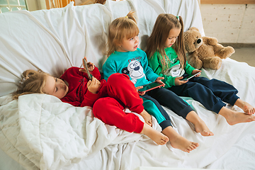 Image showing Little girls in soft warm pajamas playing at home