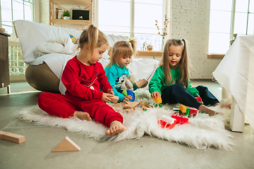 Image showing Little girls in soft warm pajamas playing at home