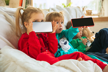 Image showing Little girls in soft warm pajamas playing at home