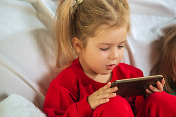 Image showing Little girl in soft warm pajama playing at home