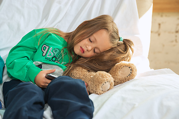 Image showing Little girl in soft warm pajama playing at home