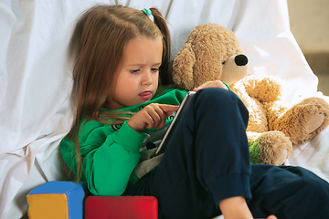 Image showing Little girl in soft warm pajama playing at home