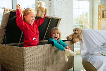 Image showing Little girls in soft warm pajamas playing at home