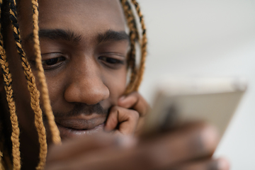 Image showing afro guy uses a cell phone and browses social media during a pandemic